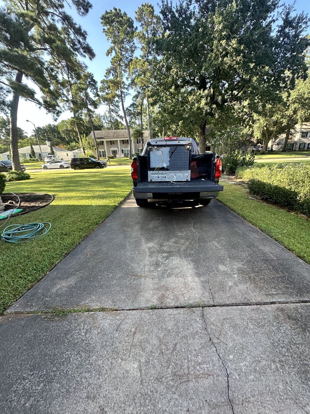 Pickup truck backed into a driveway with the tailgate down, loading up